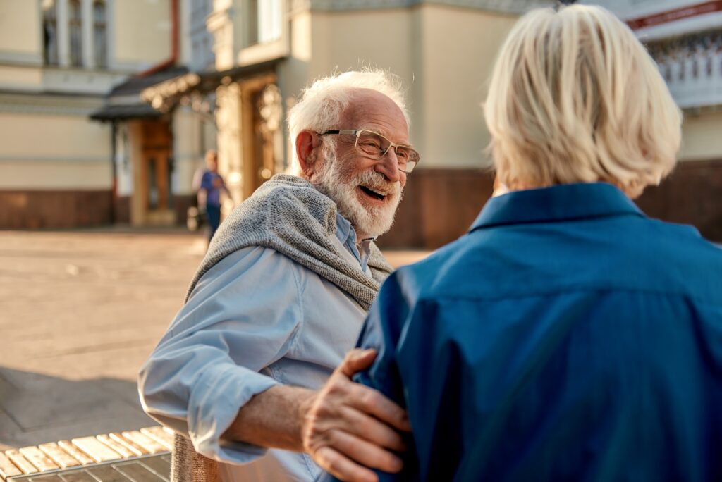 That's so funny! Happy senior bearded man in glasses looking at his wife and smiling while